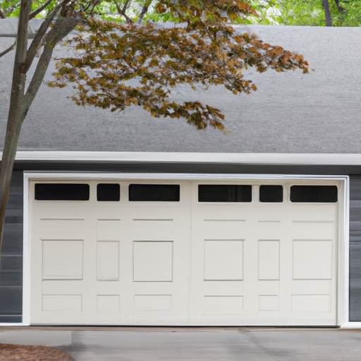 Suburban Burlington garage showing a modern sectional door with a newly replaced upper window and panel under overcast New England light.