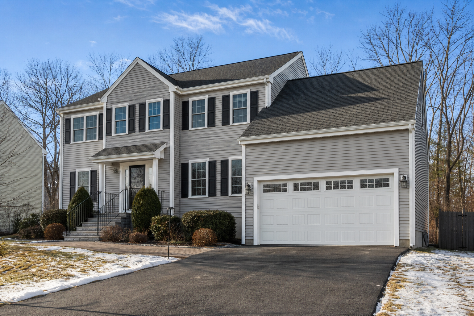 Suburban Burlington home exterior with a visible garage door and driveway in natural light